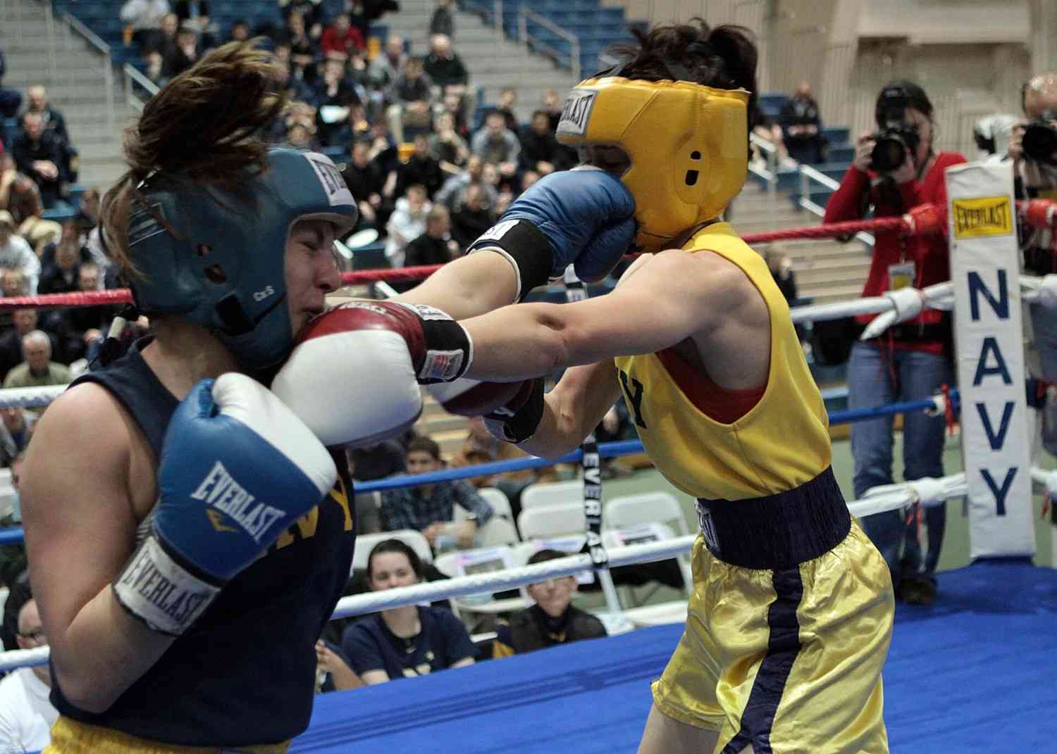 Two female boxers sparring in a boxing ring during a championship match