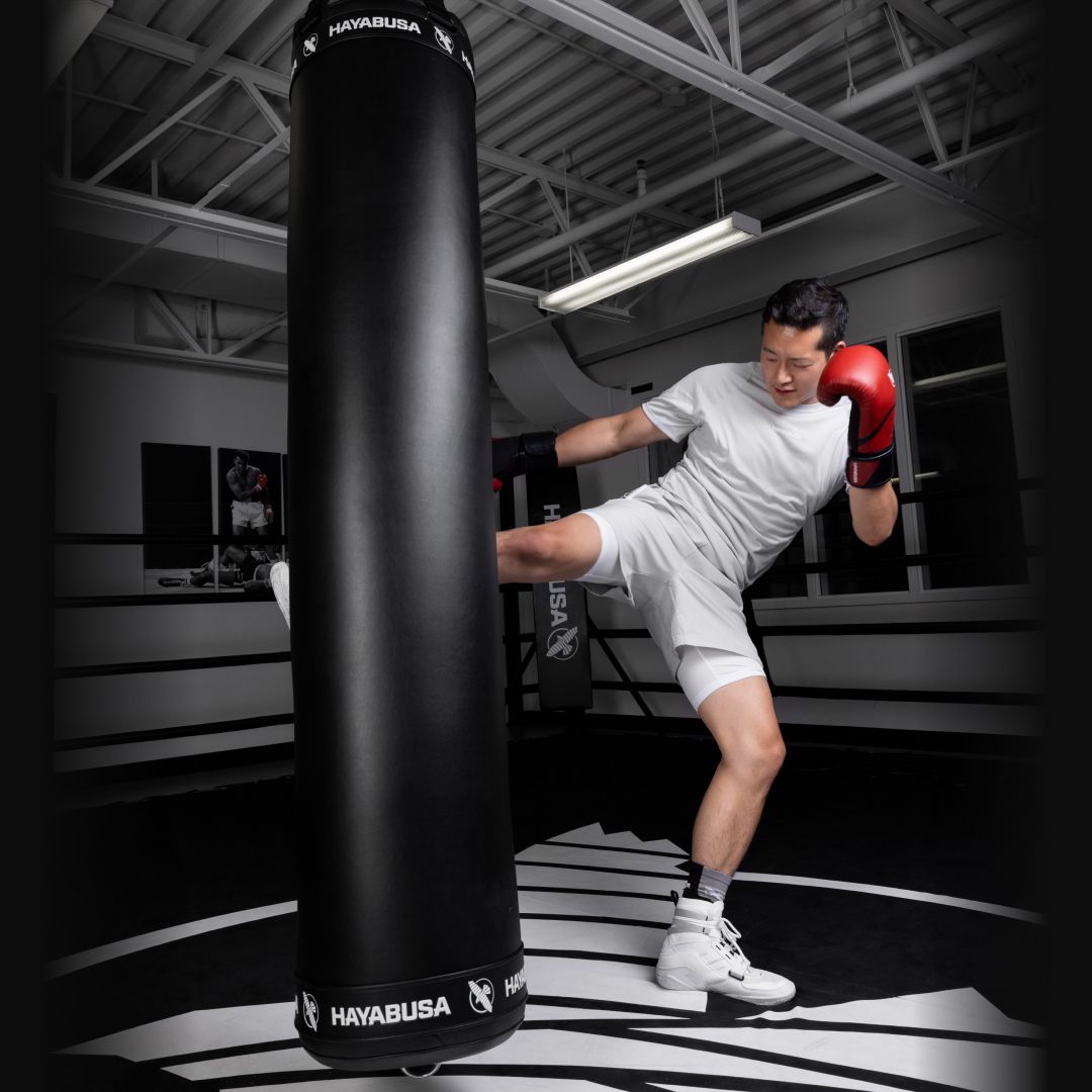 Person practicing boxing with a Hayabusa punching bag in a gym.