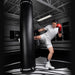 Person practicing boxing with a Hayabusa punching bag in a gym.