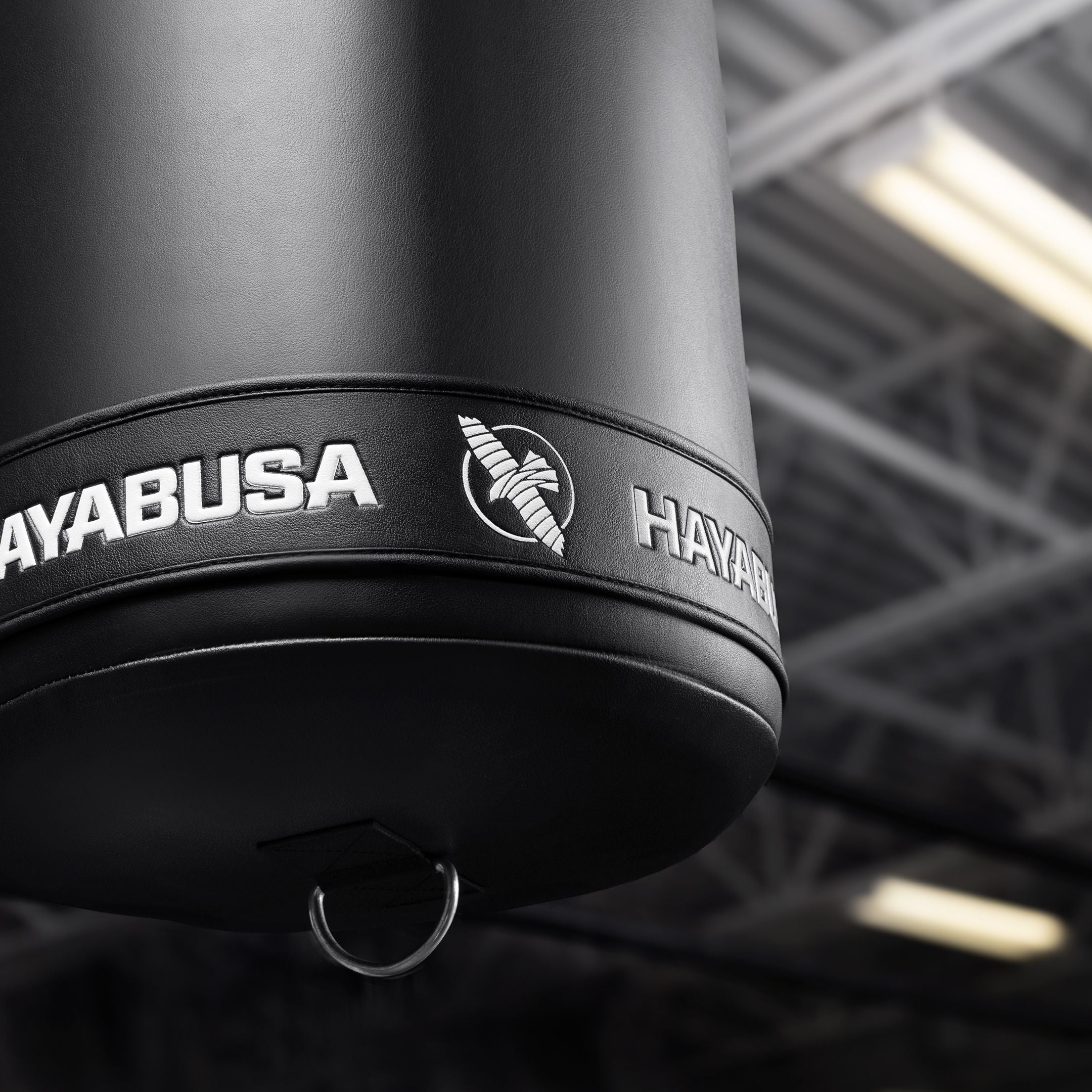 Black boxing glove with Hayabusa branding on a blurred indoor background