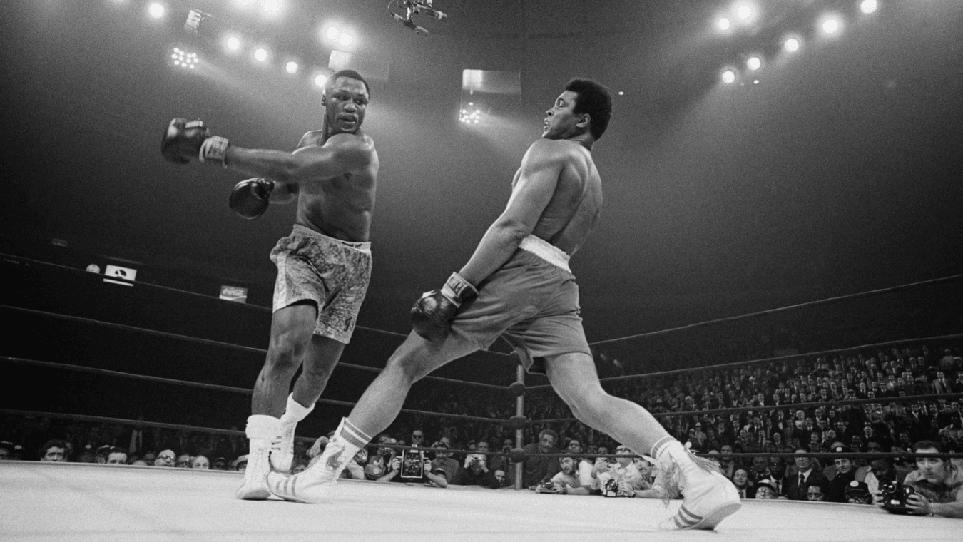 Two boxers competing in a boxing ring