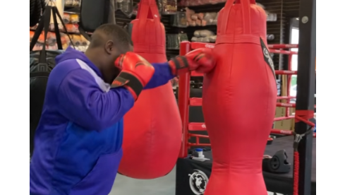 Customer practicing punches on a red heavy bag