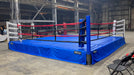 Boxing ring with blue mat and red ropes in an indoor setting