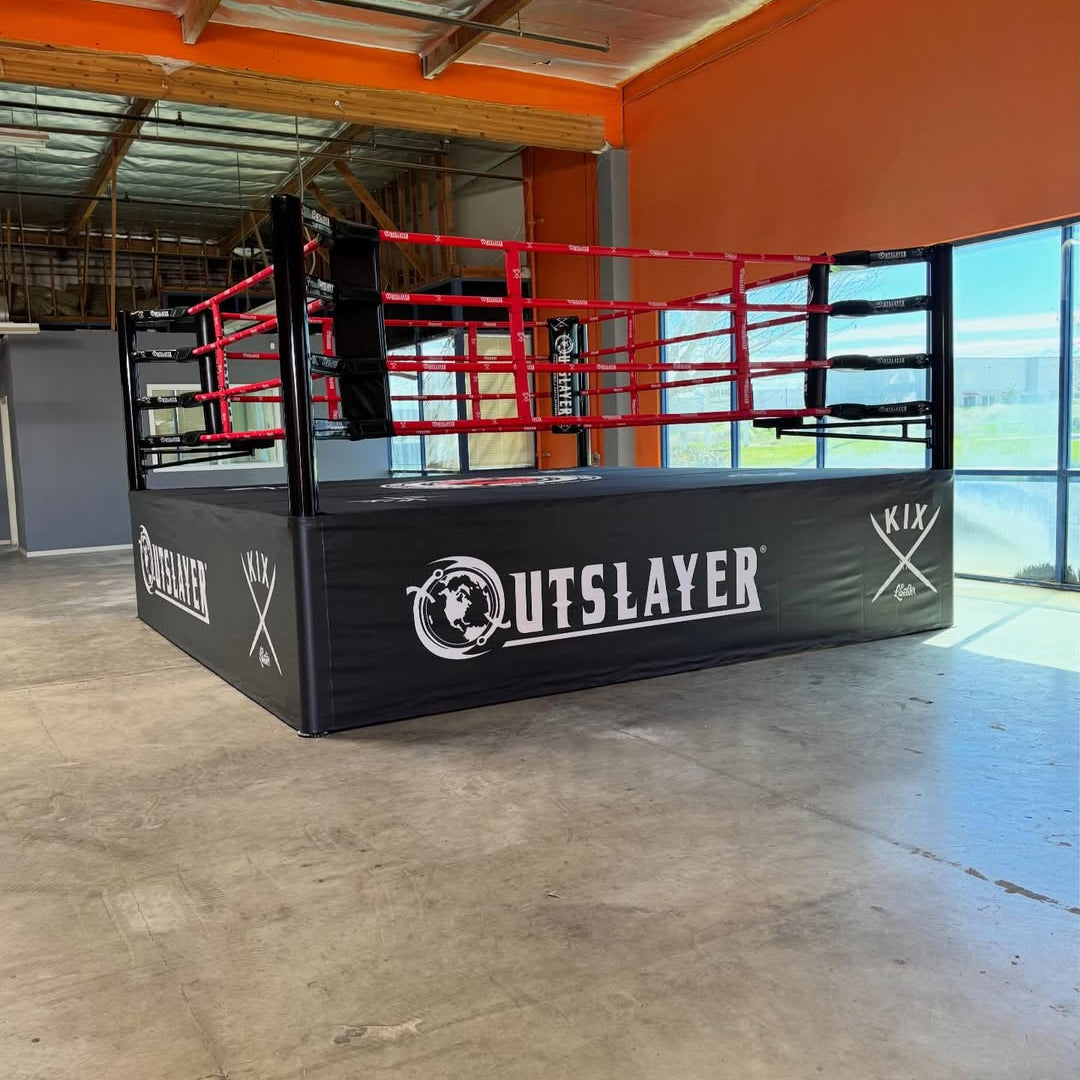 Boxing ring with 'Outslayer' branding in an indoor setting