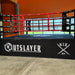 Boxing ring with 'Outslayer' and 'Kix' branding in an indoor setting.