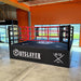 Boxing ring with 'Outslayer' and 'Kix' branding in an indoor setting.