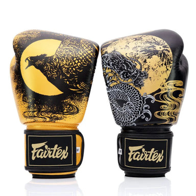 Pair of Fairtex boxing gloves with black and gold design on a white background