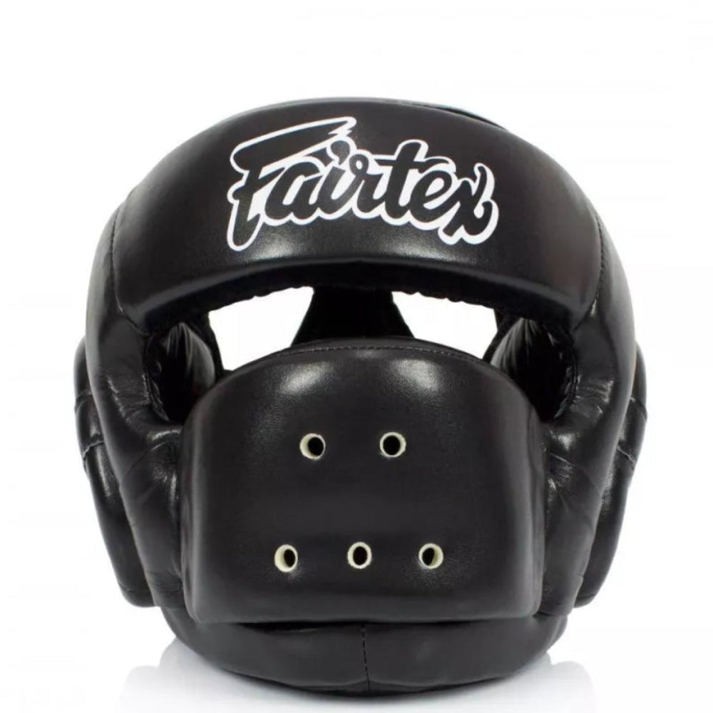 A black Fairtex boxing headguard with a white script logo on the forehead, shown against a plain white background.