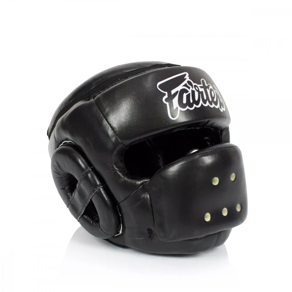 A black Muay Thai headguard with a white 'Fairtex' logo on the forehead, shown on a clean white background.