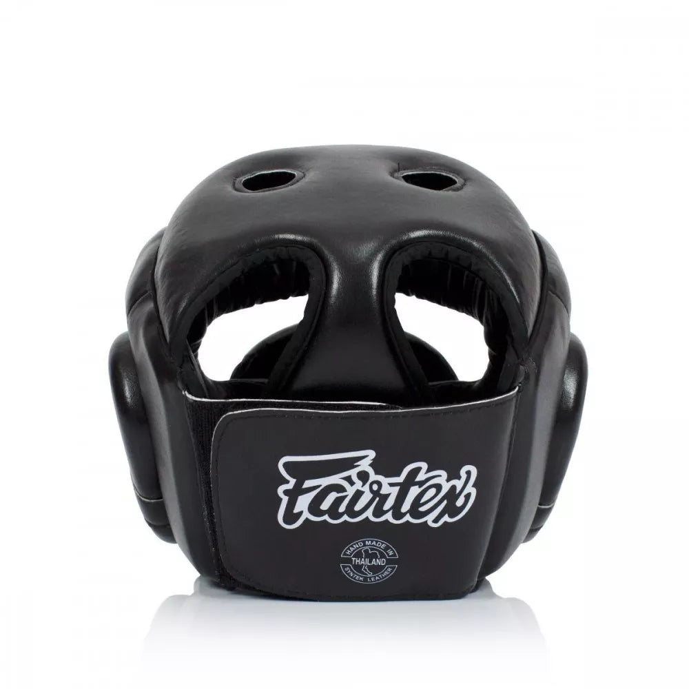 A black Fairtex boxing headguard with white logo branding, shown from a front three-quarter angle on a clean white background.