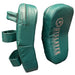 A pair of teal green UFC Slayer boxing and MMA fight gear hand pads shown on a dark, reflective surface. One pad is shown from the side with its straps, and the other is shown from the front displaying the white UFC branding.